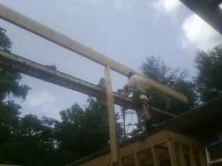 Carpenter setting a ridge beam over a new addition frame — Ice Dam Removal by Roofing Brothers in Montevideo