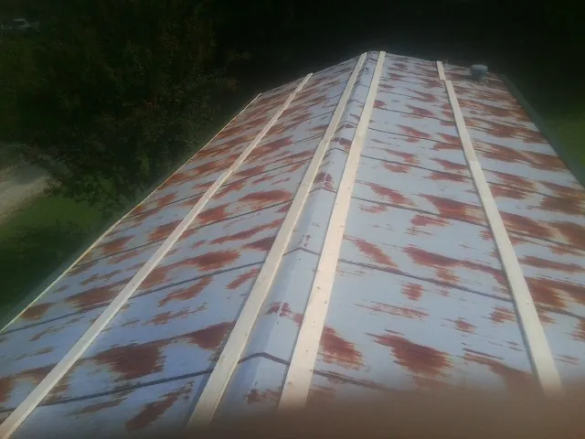 Rusted metal roof panels with new wood purlins before replacement — Storm Damage Roof Repair in Montevideo by Roofing Brothers