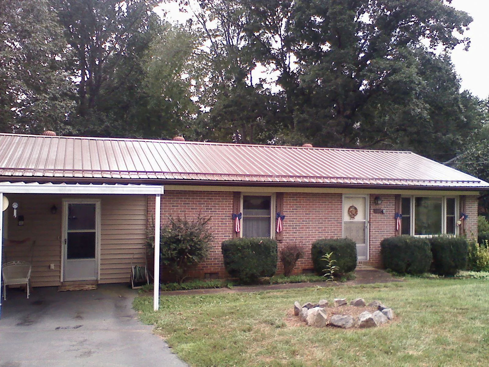 Bronze metal roof and carport on a brick ranch home — Roof Repair work by our crew in Montevideo